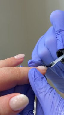 Manikürcü, manikürlü tırnaklara astar dehidratör bağıyla yapışmayı destekliyor. Güzellik stüdyosunda profesyonel güzel tırnak tasarımı yapıyorum. Yüksek kalite 4k görüntü