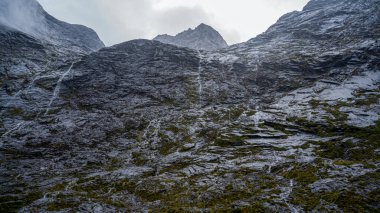 Şelaleler, yağmurlu günler, Milford Sound yolu.