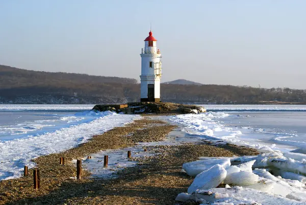 Buz kaplı deniz ve deniz feneri, Vladivostok, Rusya