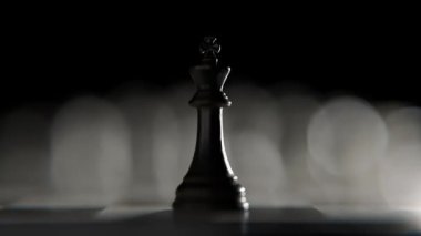 Cesur siyah satranç kralı, bir satranç tahtasına odaklanır ve yavaş yavaş berraklaşan beyaz rakipleriyle yüzleşir. Stratejiyi, liderliği ve entelektüel bir oyunun başlangıcını temsil eder..