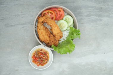 Pirinçli çıtır tavuk ve yanında salatalık, marul ve domates sosu..
