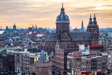 Amsterdam şehrinin gökyüzü binaları dramatik bir altın gün batımı sırasında. Fotoğraf Amsterdam Hollanda 'da alacakaranlık akşamı çekildi.