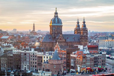 Amsterdam şehrinin gökyüzü binaları dramatik bir altın gün batımı sırasında. Fotoğraf akşamleyin Amsterdam Hollanda 'da çekildi.