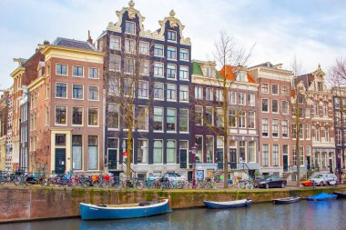 Bina boyunca bisiklet ve tekneler Amsterdam 'da kanallarda yüzüyordu. Fotoğraf Amsterdam Hollanda 'da gündüz çekilmiş.