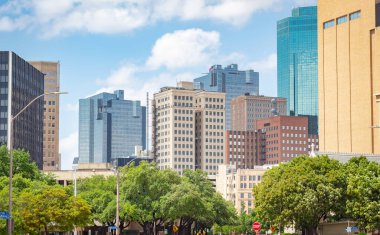 Fort Worth Texas şehrinin şehir merkezindeki binalar ve ağaçlar ufuk çizgisi. Fotoğraf parçalı bulutlu bir günde Fort Worth Texas 'ta çekildi.
