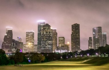 Houston Teksas şehir merkezi gökdelenleri aydınlatılmış binalar. Fotoğraf bulutlu bir gecede çekildi.