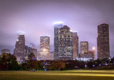 Houston Teksas şehir merkezi gökdelenleri aydınlatılmış binalar. Fotoğraf bulutlu bir gecede çekildi.