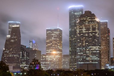 Houston Texas downtown city skyline illuminated buildings. Photo taken on a cloudy foggy evening clipart