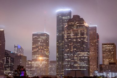 Houston Teksas şehir merkezi gökdelenleri aydınlatılmış binalar. Fotoğraf bulutlu bir gecede çekildi.