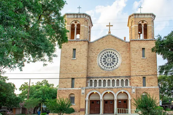 St. Patrick Katolik Kilisesi tuğlalı katedral binası. Bina yeşil ağaçlarla çevrili. Fotoğraf San Antonio Teksas 'ta çekildi.
