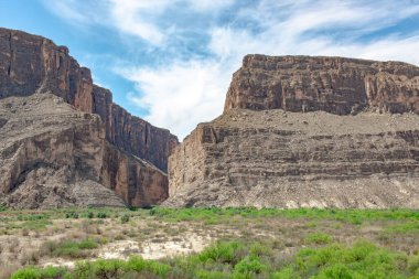 Texas 'taki Big Bend Ulusal Parkı' ndaki çöl ve kaya kayalıklarının manzarası. Fotoğraf bulutlu mavi bir gökyüzünde çekildi.