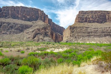 Texas 'taki Big Bend Ulusal Parkı' ndaki çöl ve kaya kayalıklarının manzarası. Fotoğraf bulutlu mavi bir gökyüzünde çekildi.