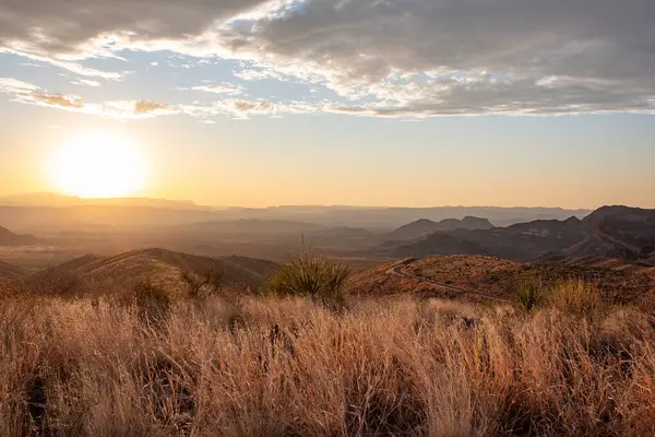 Teksas 'taki Big Bend Ulusal Parkı' nın çim tarlalarında ve çöllerinde dramatik bir altın gün batımı bulutu.