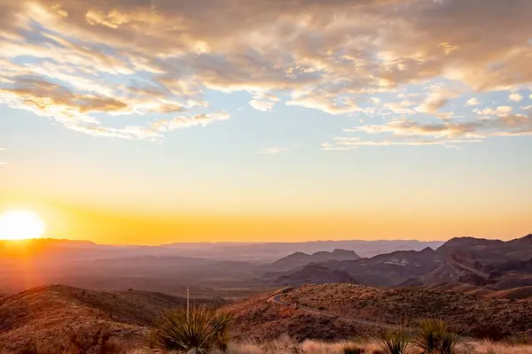 Teksas 'taki Big Bend Ulusal Parkı' nın çim tarlalarında ve çöllerinde dramatik bir altın gün batımı bulutu.