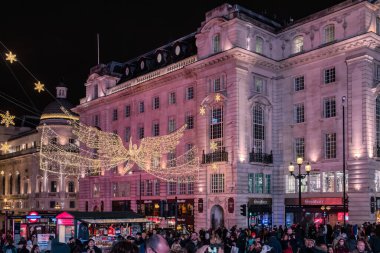 Londra şehir merkezinde ışıklandırılmış bir merkez cadde. Fotoğraf, Londra 'da Picadilly Sirki yakınlarında akşam saatlerinde çekilen yoğun bir kavşak.