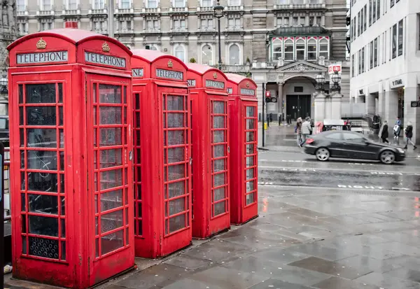 Londra şehir merkezindeki bir cadde boyunca dizilmiş kırmızı antika telefon kulübeleri. Fotoğraf İngiltere 'de Londra' da çekildi