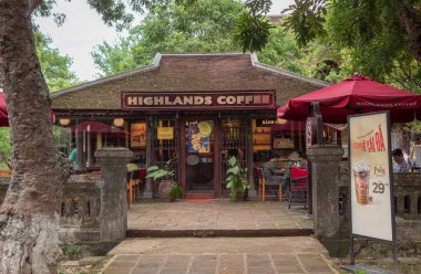 Highlands Kafe binası, yemyeşil ağaçlarla çevrili bir parkta.