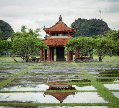 Nihn Binh Vietnam 'daki Hoa L Antik Başkenti' nde dağlarla ve tropikal ağaçlarla geleneksel pagoda yapısı yansıması