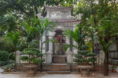 Hanoi Vietnam 'daki gri taş pagoda kapısı yemyeşil ağaçlarla çevrili.