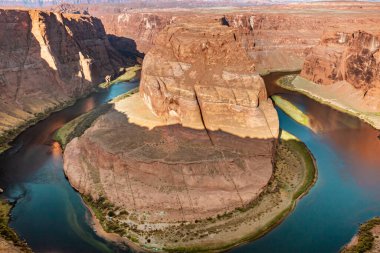 Horseshoe Bend Red Rock uçurumları ve Kuzey Arizona çölündeki Grand Canyon 'daki Colorado nehir manzarası. Fotoğraf açık mavi bir gökyüzünde çekildi.