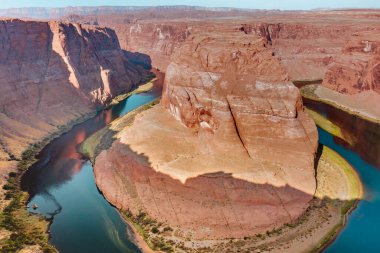 Horseshoe Bend Red Rock uçurumları ve Kuzey Arizona çölündeki Grand Canyon 'daki Colorado nehir manzarası. Fotoğraf açık mavi bir gökyüzünde çekildi.