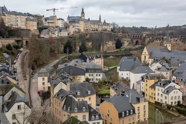 Eski Lüksemburg şehrindeki gösterişli Saint-Jean-du-Grund katedralinin geleneksel ve renkli mimarisi. Fotoğraf bulutlu bir kış gününde çekildi.