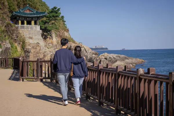 Aynı kıyafetleri giyen çift tapınağa doğru yürüyor. Fotoğraf Güney Kore, Sokcho 'daki Naksansa Tapınağı' nda çekildi.