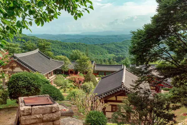 Güney Kore 'deki Buseoksa Budist Tapınağı kompleksindeki geleneksel Kore mimarisi ve yemyeşil orman ve dağlar bulutlu bir günde