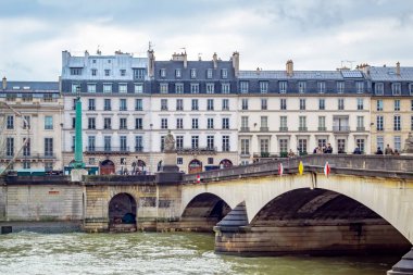 Soğuk ve bulutlu bir kış gününde Seine Nehri boyunca Fransız Paris binalarının manzarası.