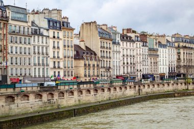 Soğuk ve bulutlu bir kış gününde Seine Nehri boyunca Fransız Paris binalarının manzarası.