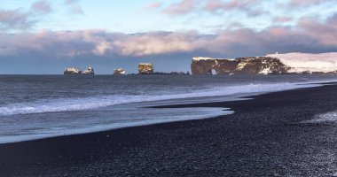 Güzel Reynisfjara siyah kumsal Vik İzlanda 'da. Fotoğraf bulutlu bir kış sabahı çekildi.