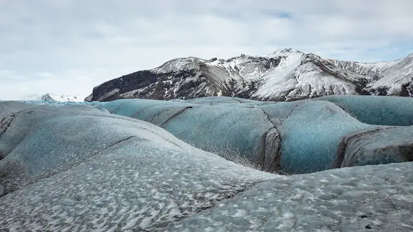 İzlanda 'daki Vatnajokull buzulunun güzel mavi buzulları ve dağları. Fotoğraf bulutlu bir günde çekildi. 