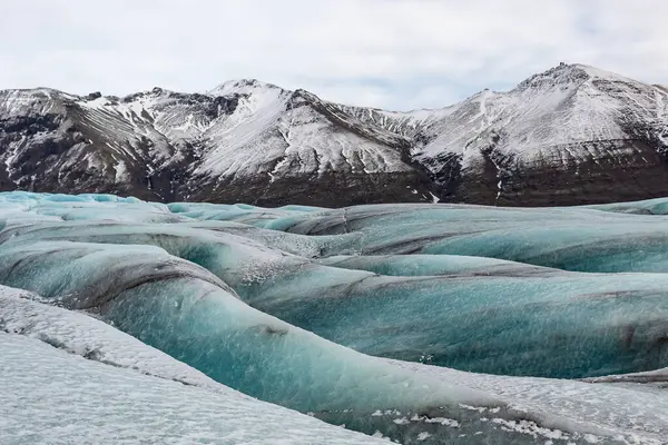 İzlanda 'daki Vatnajokull buzulunun güzel mavi buzulları ve dağları. Fotoğraf bulutlu bir günde çekildi. 