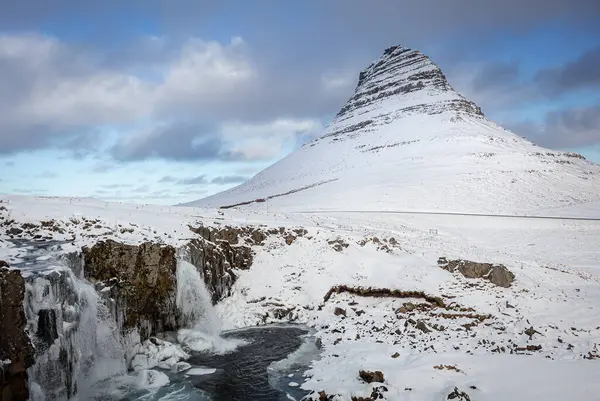 İzlanda 'nın Snfellsnes yarımadasında yer alan Kirkjufell Dağı karla kaplıydı. Fotoğraf, kışın bulutlu bir günde çekildi.