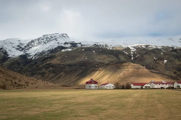 Bir dağın eteğinde ıssız bir muhit. Fotoğraf bulutlu bir günde İzlanda 'da çekildi.