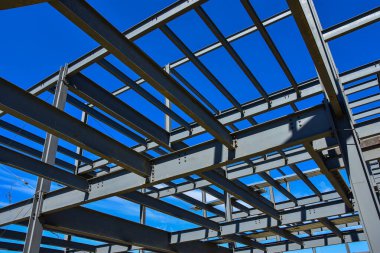 Çelik kirişler inşaat halindeki yeni ticari bina için diğer yapısal üyelere destek sağlıyor.