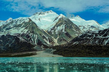 Engebeli karlı dağlar ve Alaska 'daki Buzul Körfezi Ulusal Parkı' nın buzlu suları..