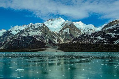 Engebeli karlı dağlar ve Alaska 'daki Buzul Körfezi Ulusal Parkı' nın buzlu suları..