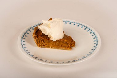 Bir dilim lezzetli kabak turtası ve tepside çırpılmış krema..