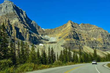 1. Otoyol Banff Ulusal Parkı, Alberta, Kanada 'da ormanları ve engebeli görkemli dağları geçiyor..