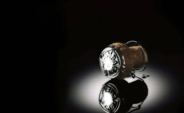 Siyah yansıtıcı arka planda şampanya mantarı.