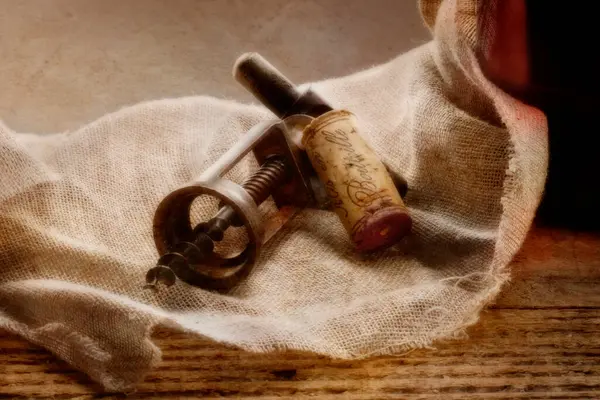 Ahşap arka planda tirbuşonlu şarap şişesi..