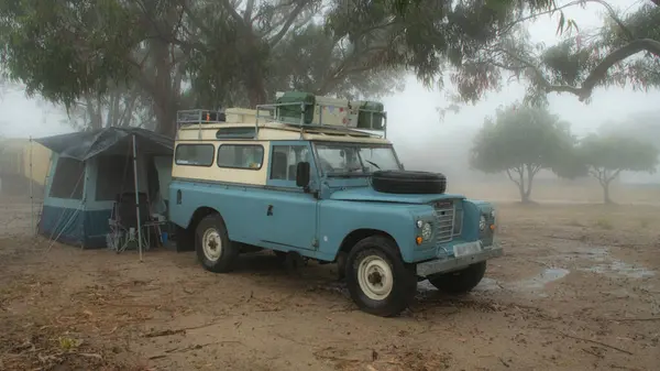 LanRover ve çadır sıcak Fas yağmurunda kamp kuruyor.