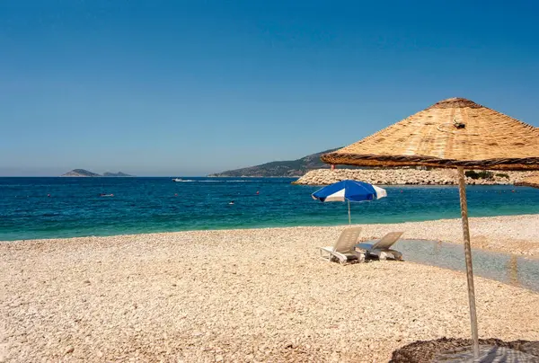 Kalkan 'daki sahil. Güney Kalkan 'da Kalkan' daki çakıl taşı plajında güneş şemsiyeleri.