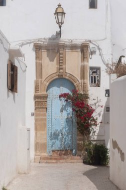 Bougainvillea ve Rabat 'taki eski Oudayas Kasbah' ın dar sokaklarında eski bir kapı..