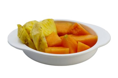 Lezzetli ananas ve papaya dilimleri sade beyaz bir kasede güzel bir şekilde sunulmuştur. Sağlıklı beslenmek ve tropikal meyve temaları için mükemmeldir..