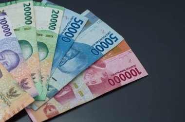 Endonezya Rupiah notlarının koyu bir yüzeye yerleştirilmiş renkli çeşitleri.