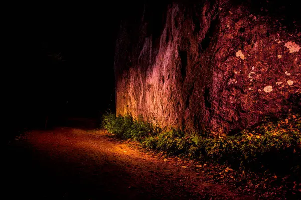 Gece vakti, yanında yol ve küçük bitki örtüsü olan renkli kayalarla dolu gizli bir bahçe. İlginç bir jeolojik ve manzaralı yer. Peri masalı mekanı. Yatay çerçeve.