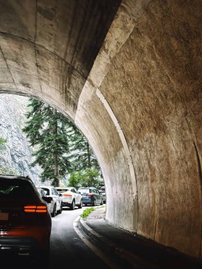 A traffic jam of cars in a tunnel in the mountains clipart