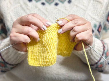 Kadın eli ve sarı örgü.